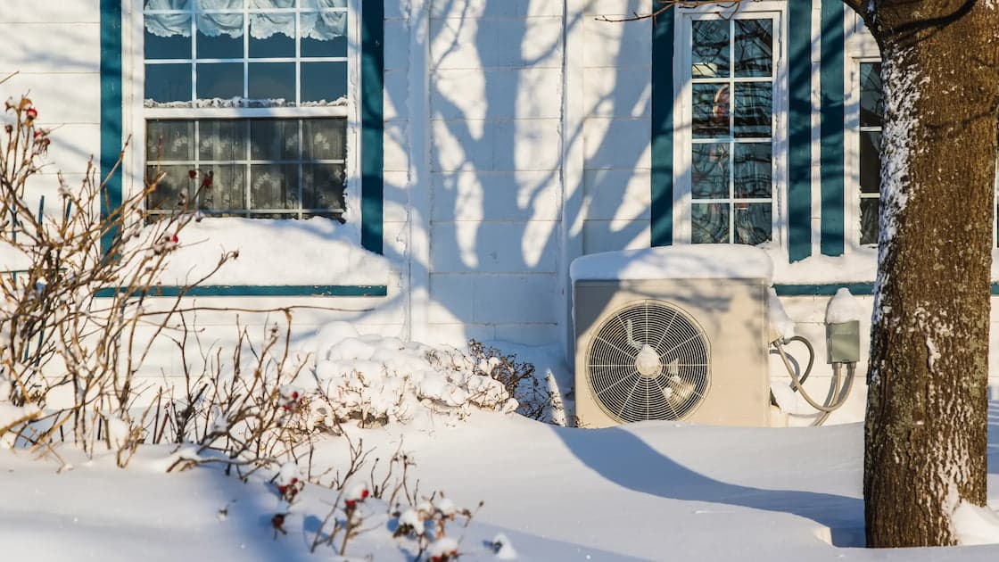 Wärmepumpe an Hausseite im Schnee