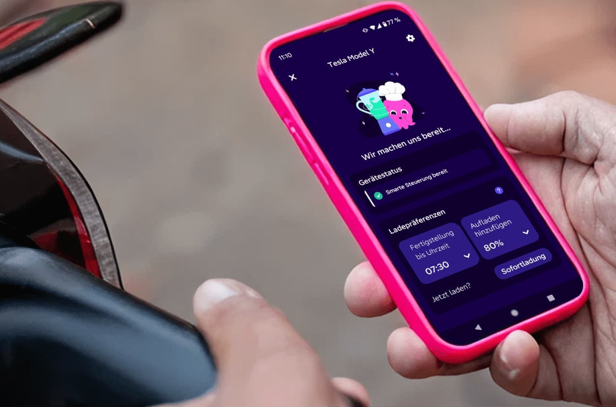 Eine Person lädt ein E-Auto und hat ein Handy mit der Octopus Energy App in der Hand